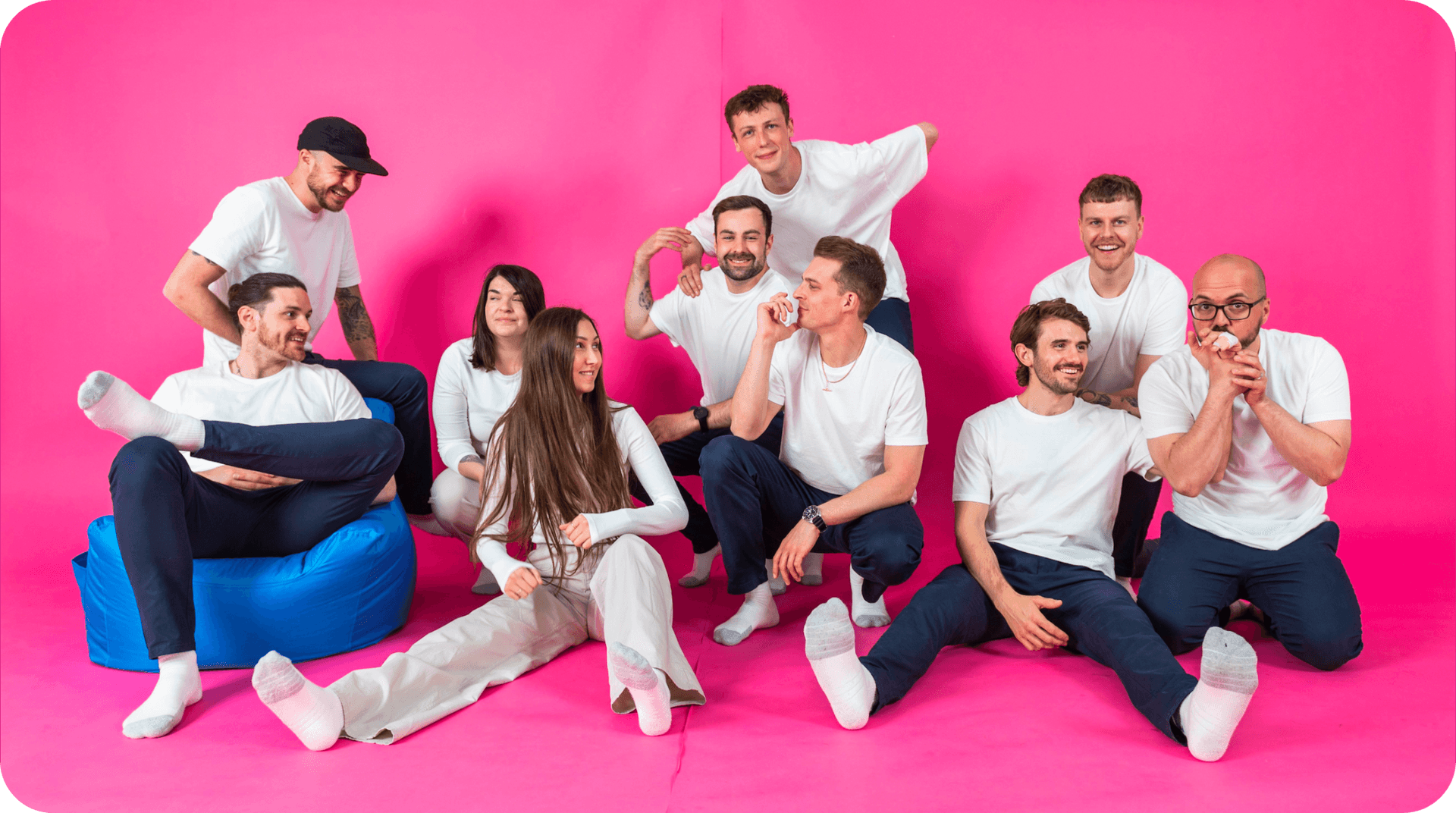 Team members of Salience marketing agency posing in coordinated white outfits against a pink backdrop.