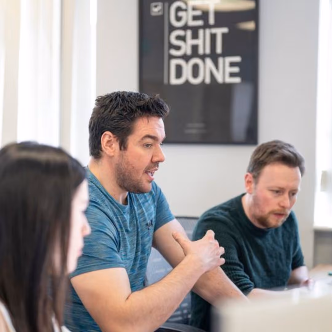 Three professionals collaborating on business growth strategy in meeting