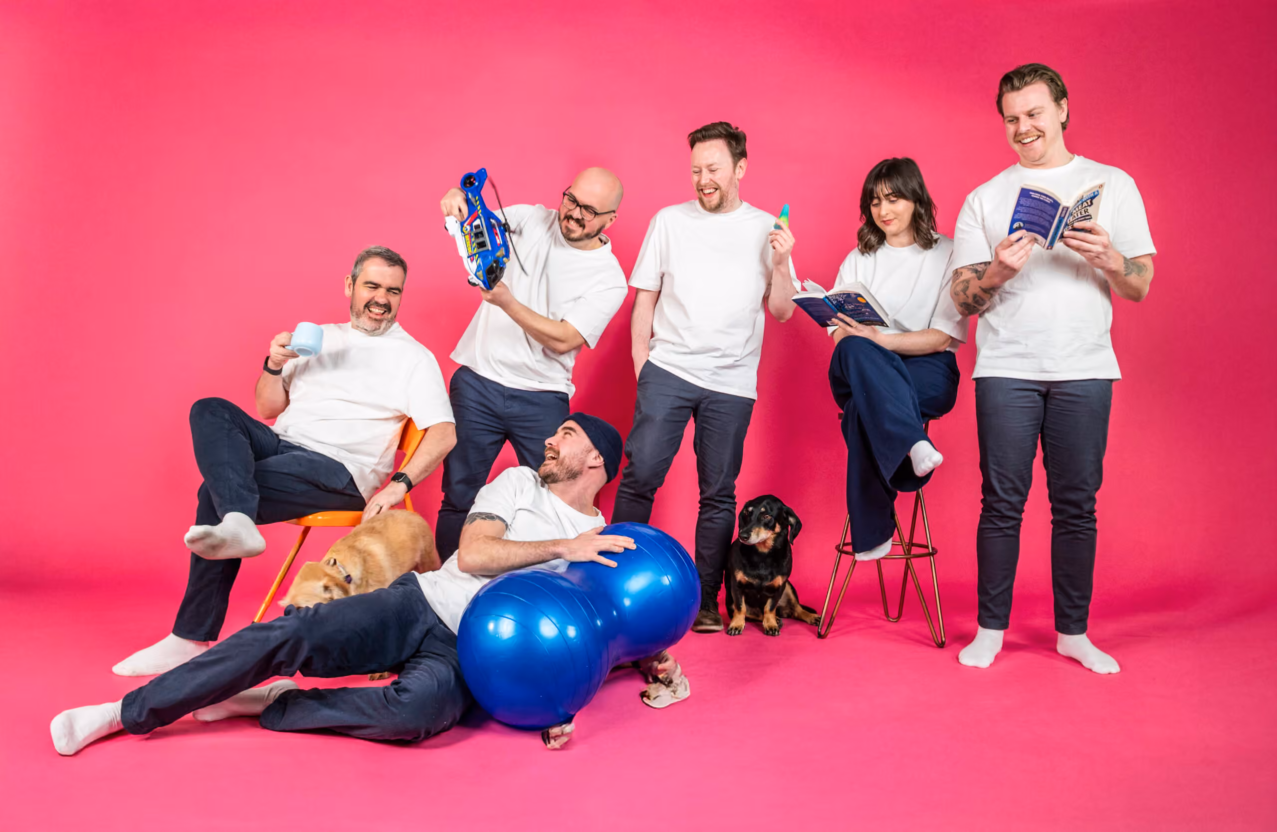 Salience e-commerce marketing team posing in white shirts with exercise balls and dog