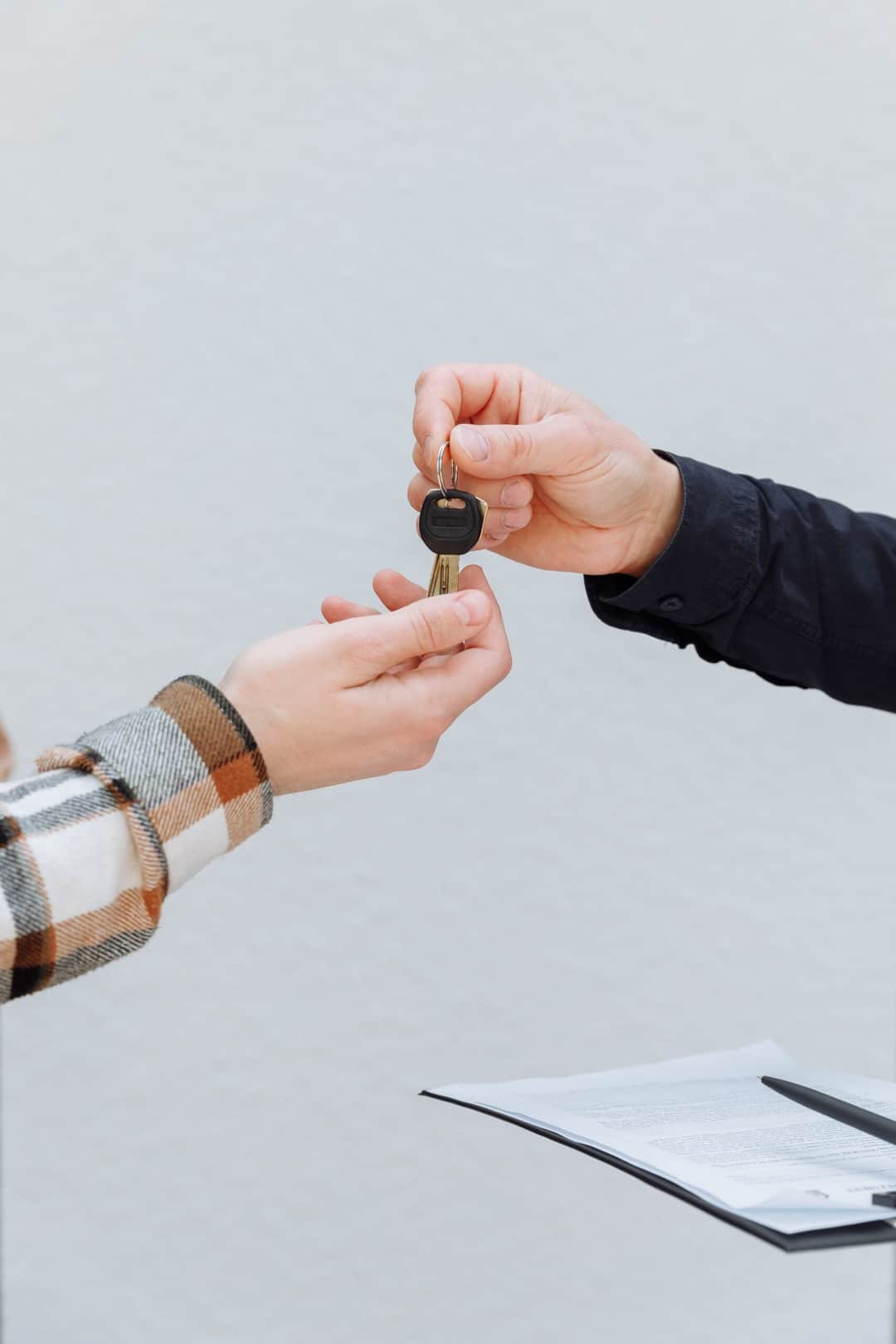 Close-up of hands exchanging car keys, symbolizing a business transaction. (Photo: Thirdman via Pexels)