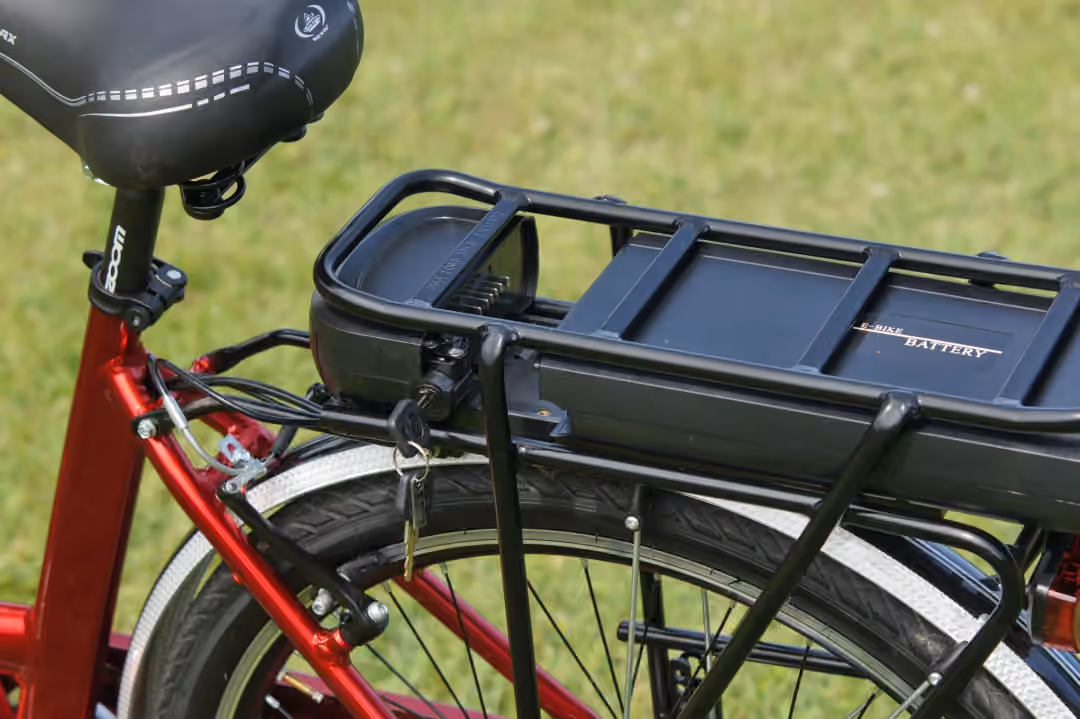 Detailed view of an electric bicycle battery mounted on a rear rack, highlighting the key-lock mechanism. (Photo: alex via Pexels)