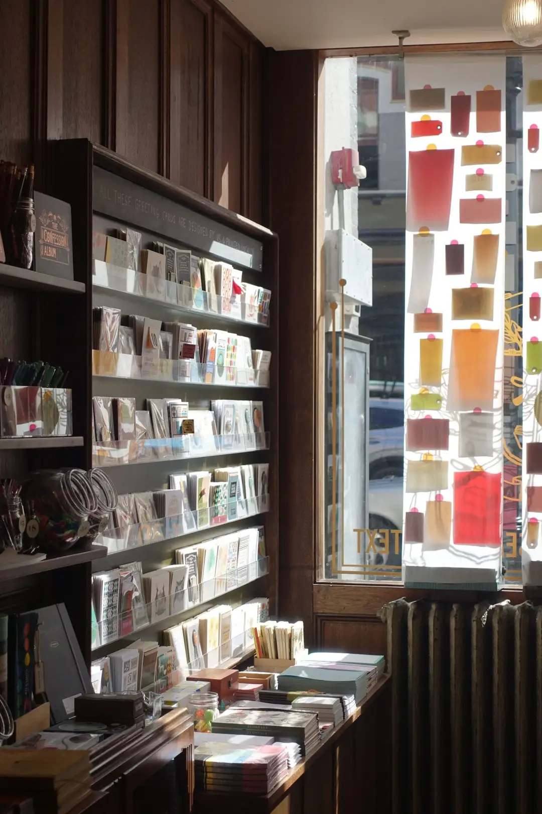 A charming stationery shop with shelves of cards lit by sunlight from a window display. (Photo: casper lin via Pexels)